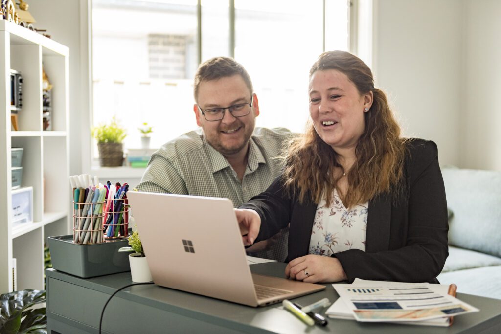 contact us. two people looking at a screen discussing work